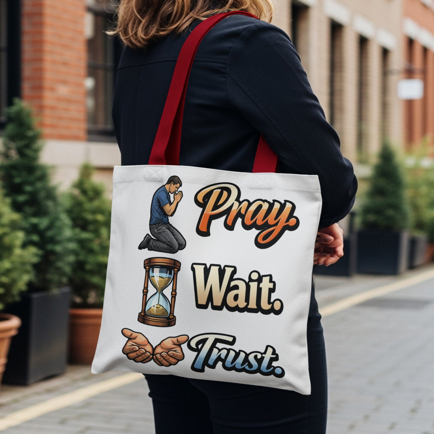 White tote bag with Pray, Wait, Trust text and related graphics.