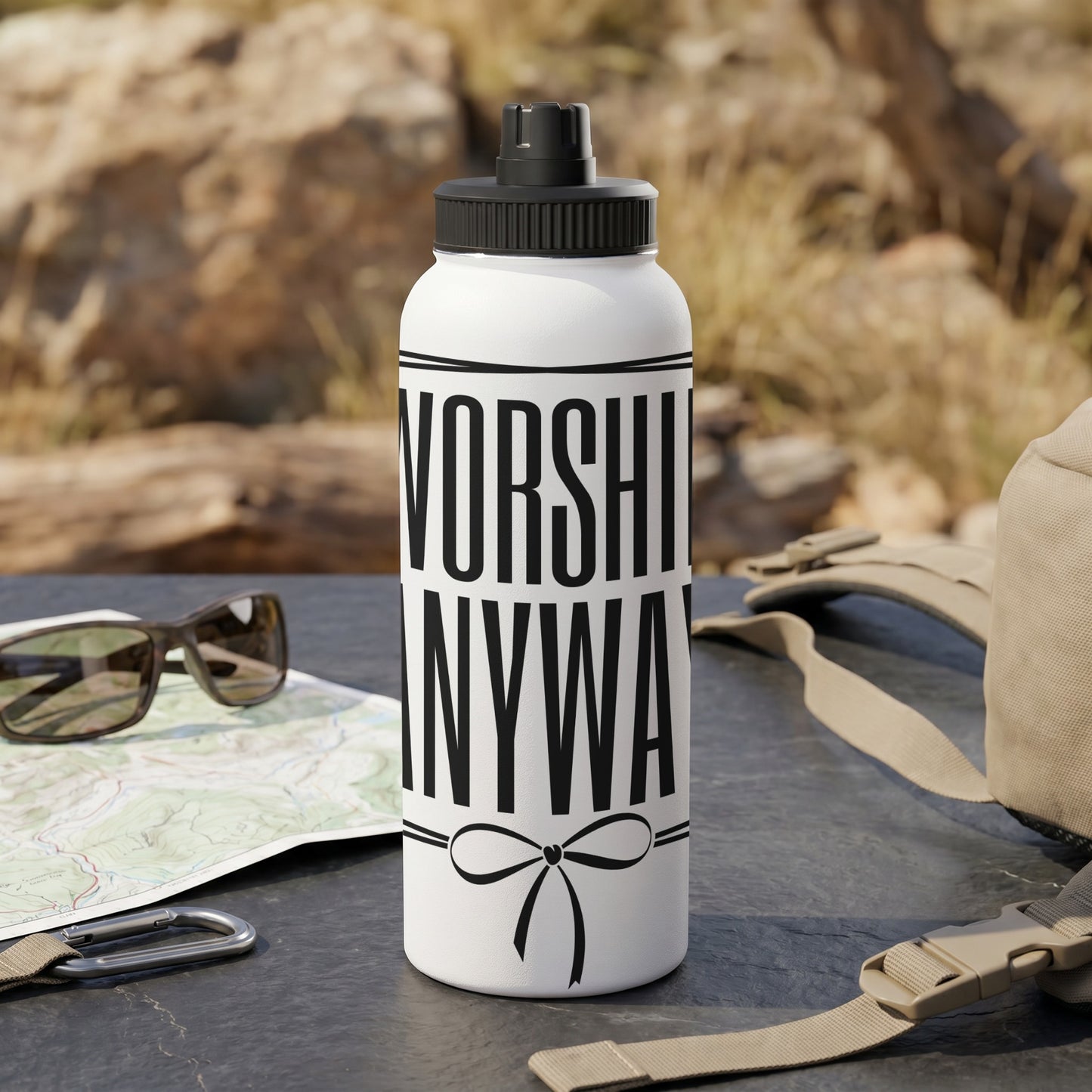 White water bottle with black text "WORSHIP ANYWAY" and a black bow graphic.