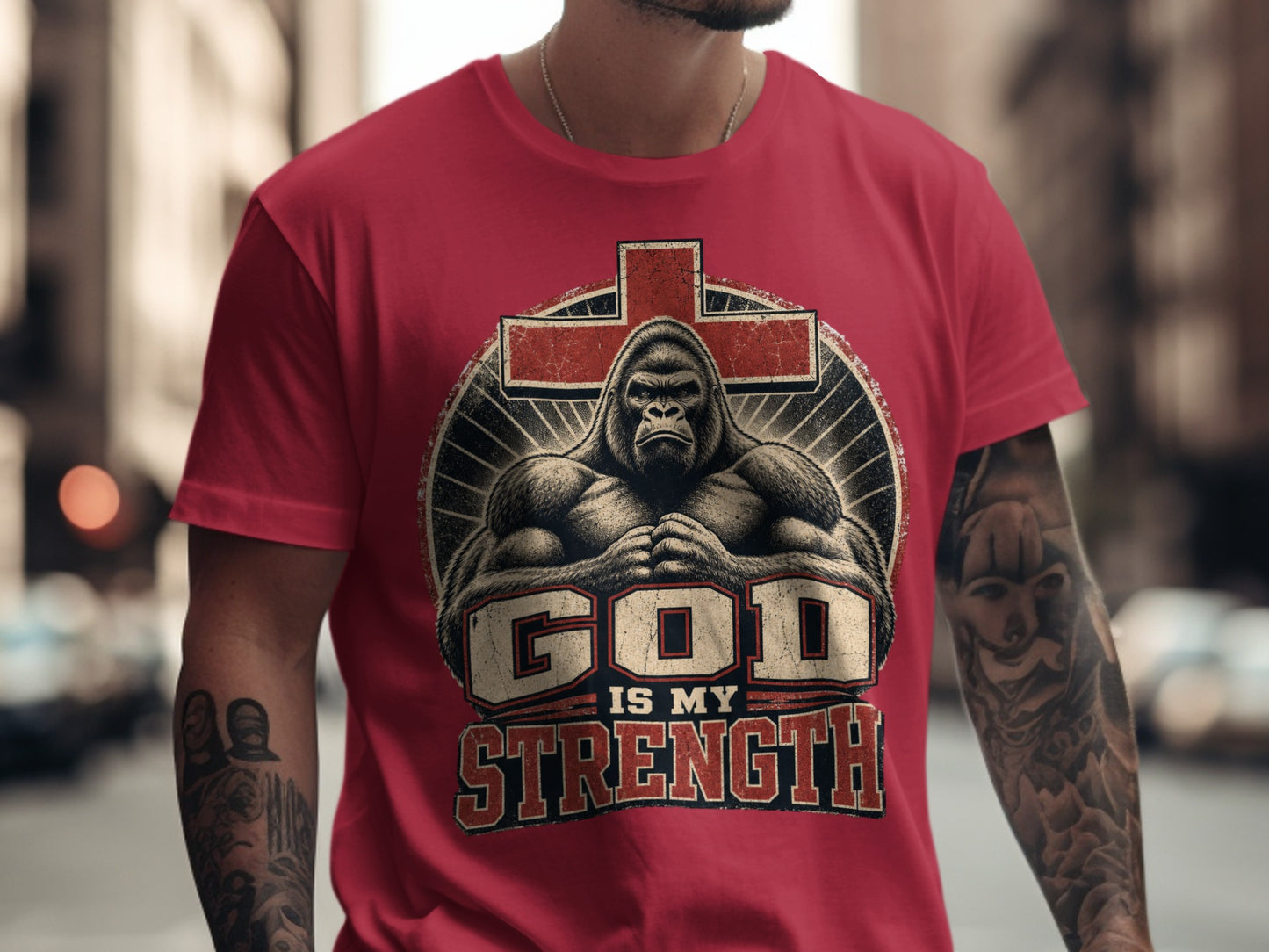 Red t-shirt with gorilla and text "GOD IS MY STRENGTH" on a cross.