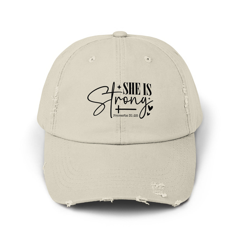 Distressed beige baseball cap with "SHE IS Strong" and "Proverbs 31:25" text.