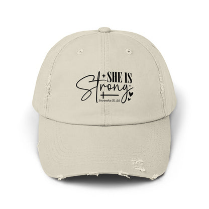 Distressed beige baseball cap with "SHE IS Strong" and "Proverbs 31:25" text.
