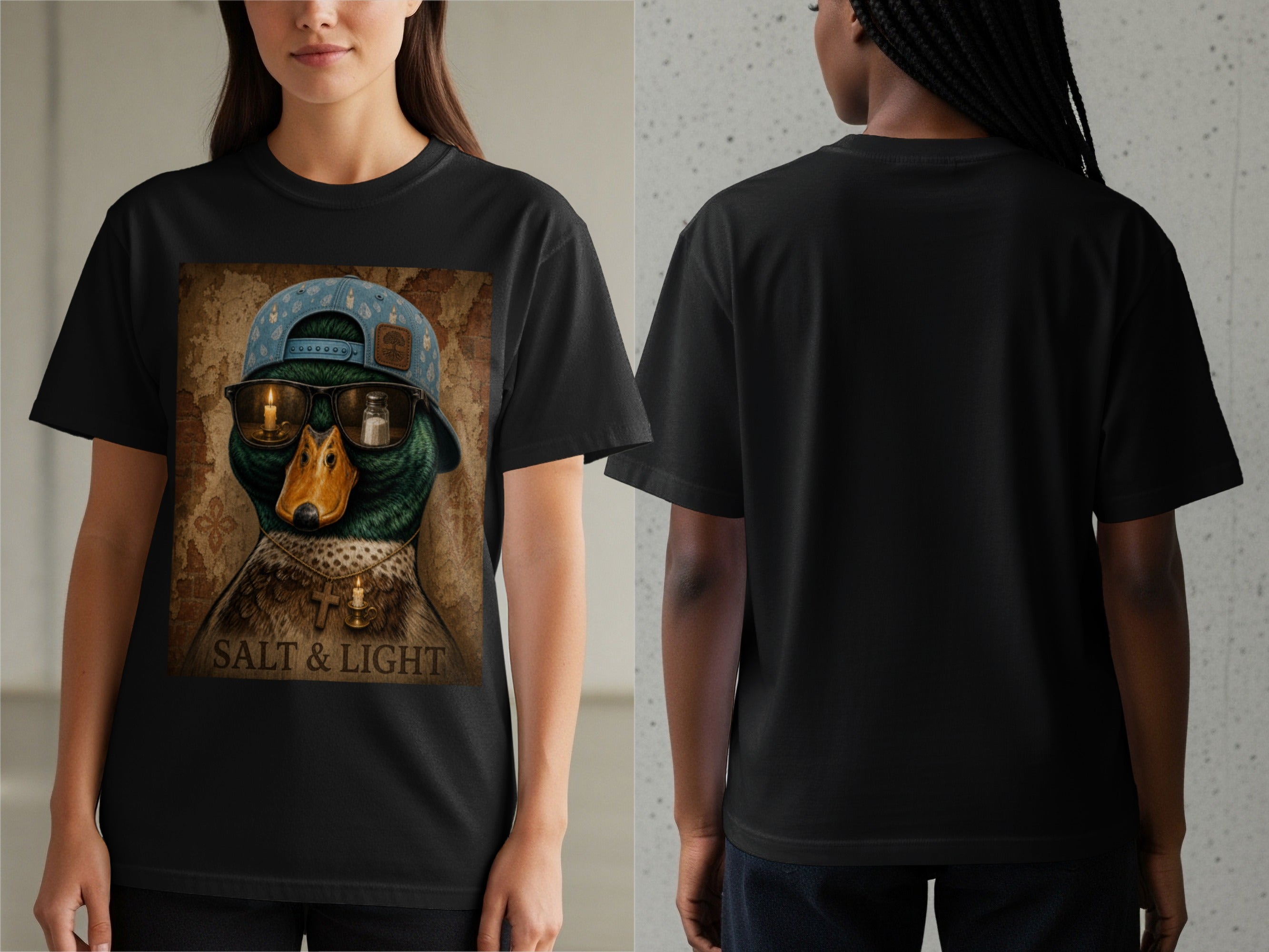 Black t-shirt with a graphic of a duck wearing a hat, sunglasses with candles and salt, and a cross necklace. Text reads "SALT & LIGHT".