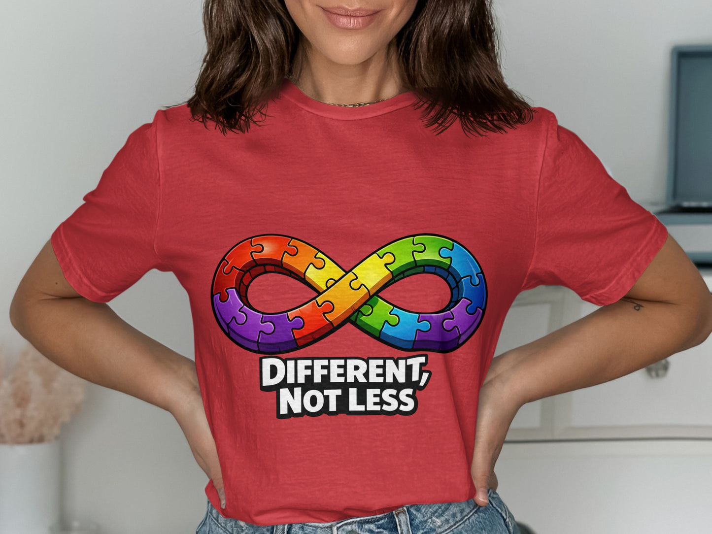 Red t-shirt with a colorful infinity symbol made of puzzle pieces and the text "DIFFERENT, NOT LESS".