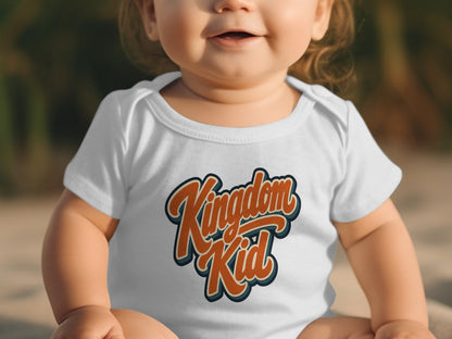 Baby wearing white onesie with "Kingdom Kid" text in orange and blue outline.