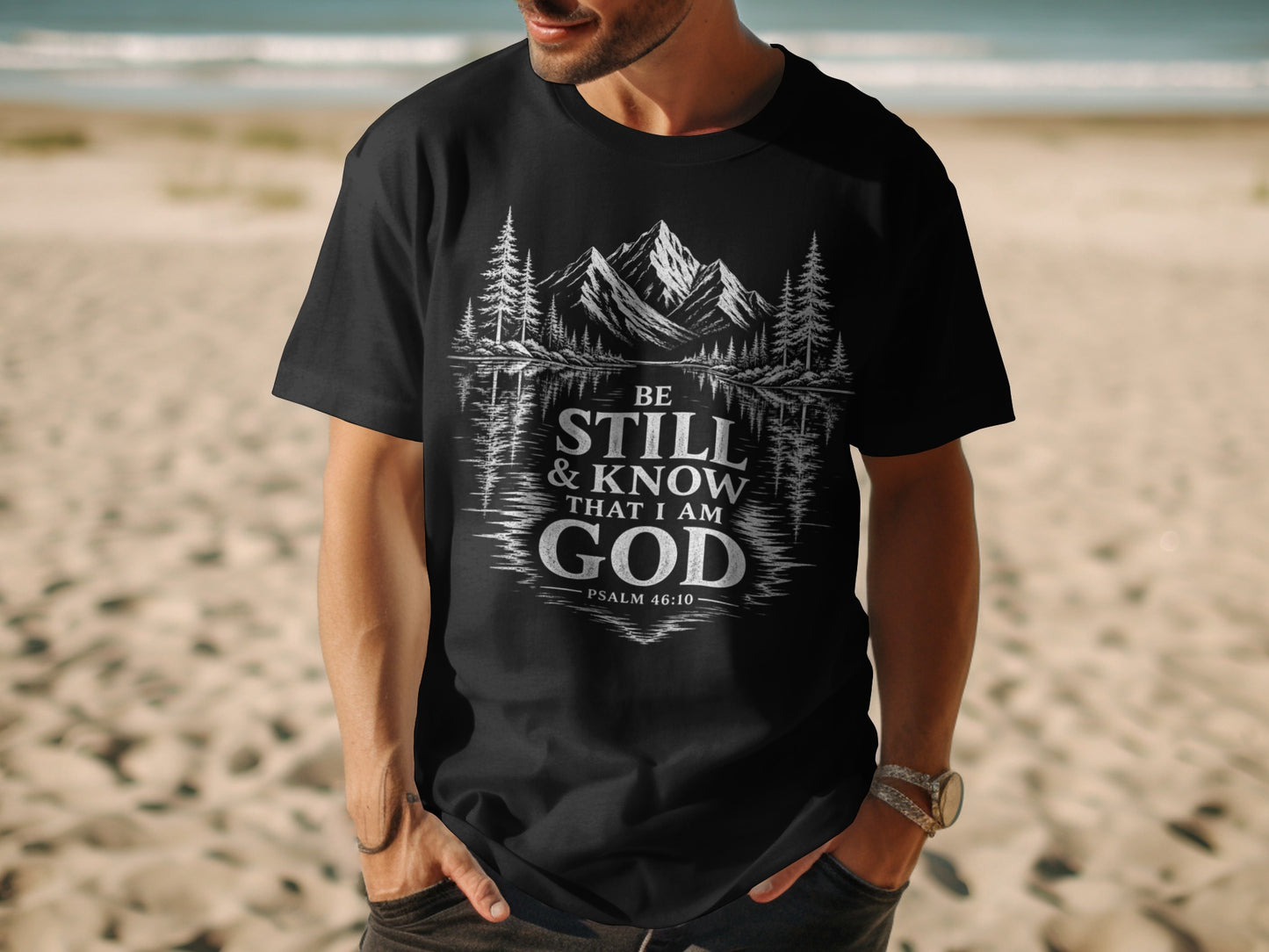 Black t-shirt with "Be Still & Know That I Am God Psalm 46:10" text and mountain landscape graphic.