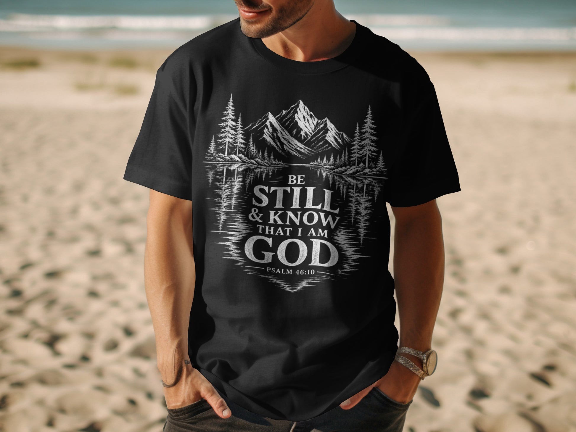 Black t-shirt with "Be Still & Know That I Am God Psalm 46:10" text and mountain landscape graphic.