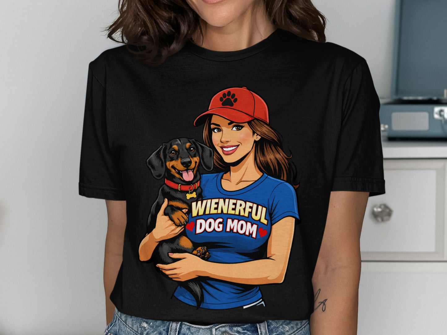 Illustration of a woman in a red hat holding a dachshund with "Wienerful Dog Mom" text.