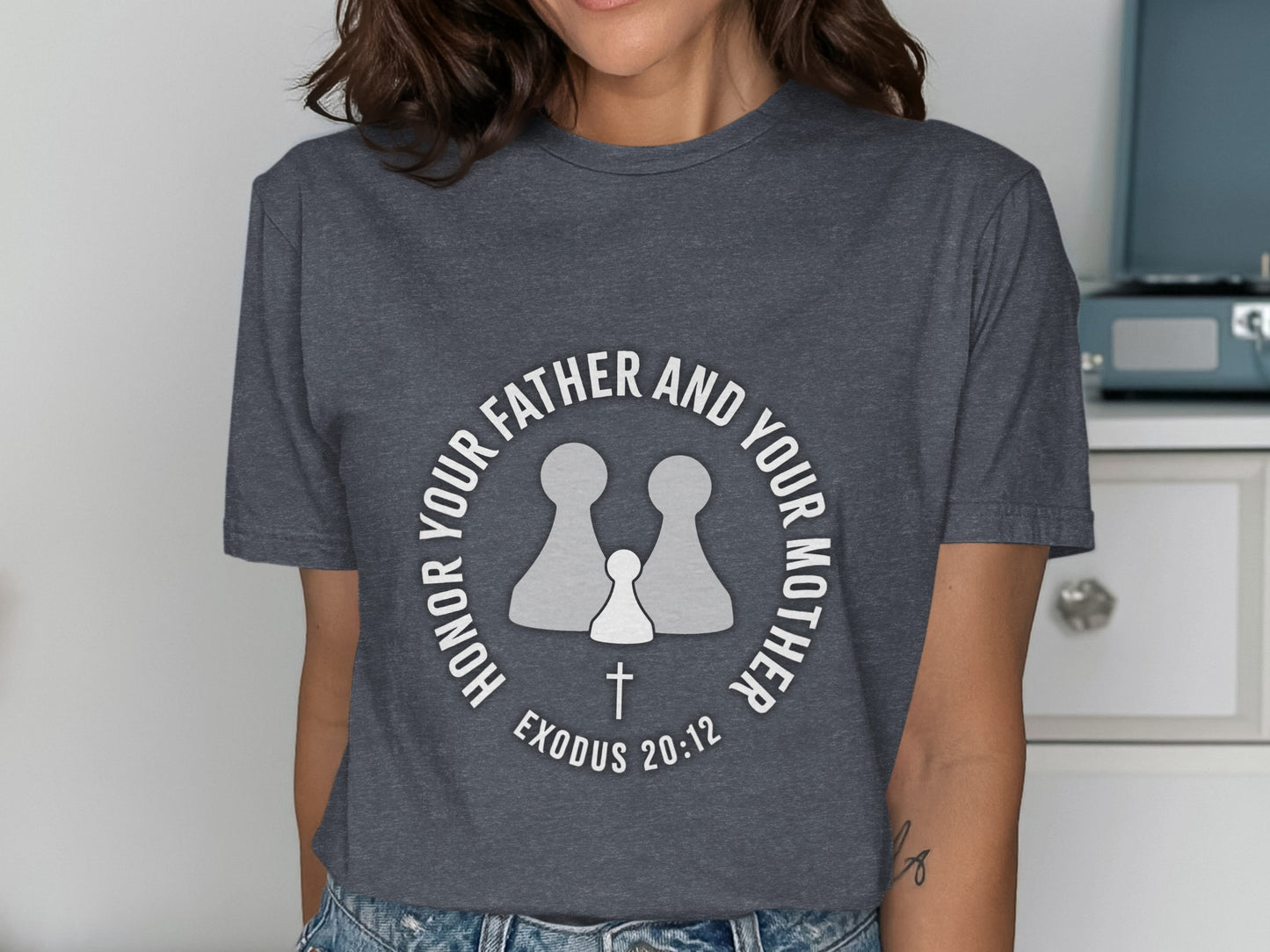 Dark grey t-shirt with a circular design featuring two large figures, a small figure, and a cross.