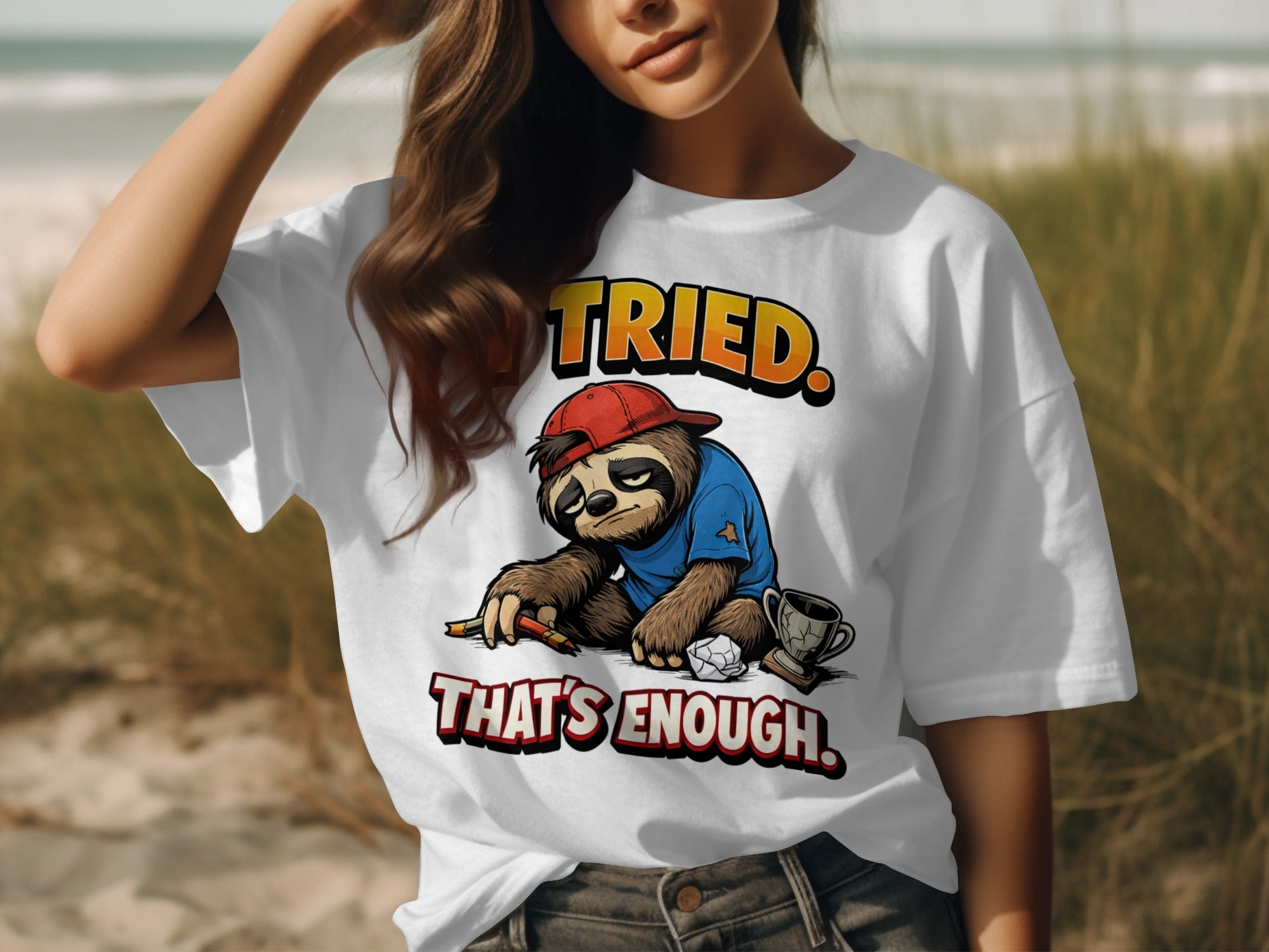 White t-shirt with a cartoon sloth holding pencils, text "TRIED. THAT'S ENOUGH.".