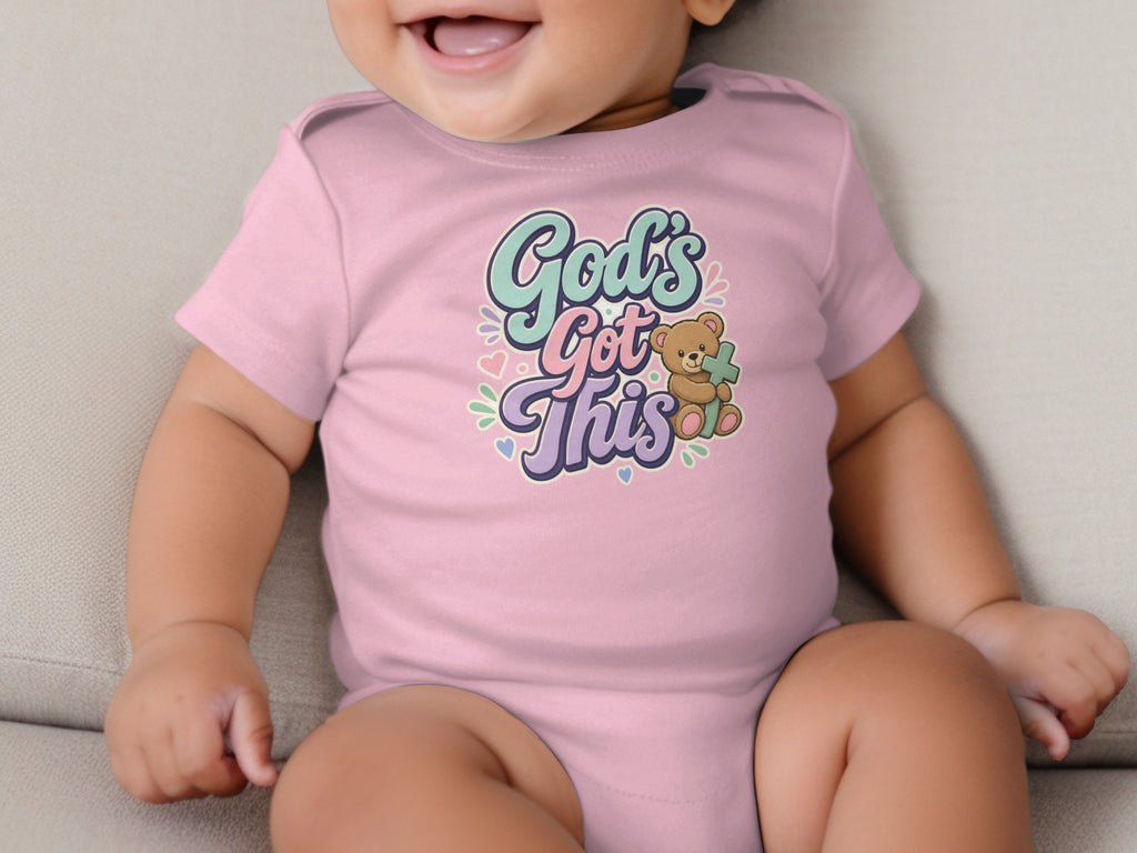 Pink baby onesie with "God's Got This" text and a teddy bear holding a cross.