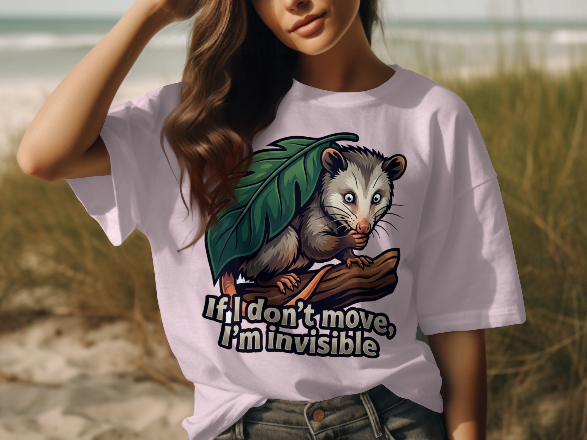 T-shirt with opossum hiding under a leaf, text reads "If I don't move, I'm invisible".