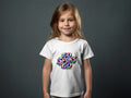 Girl wearing white t-shirt with colorful "GO SPURS GO" graphic.