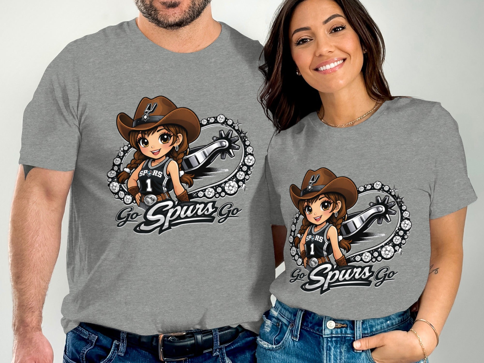 Two grey t-shirts displayed on a man and woman, each featuring a cartoon cowgirl with a Spurs basketball jersey.