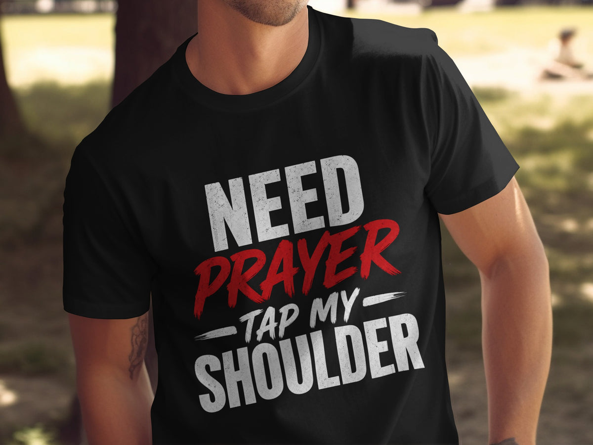 Black t-shirt with white and red text reading "NEED PRAYER - TAP MY SHOULDER".
