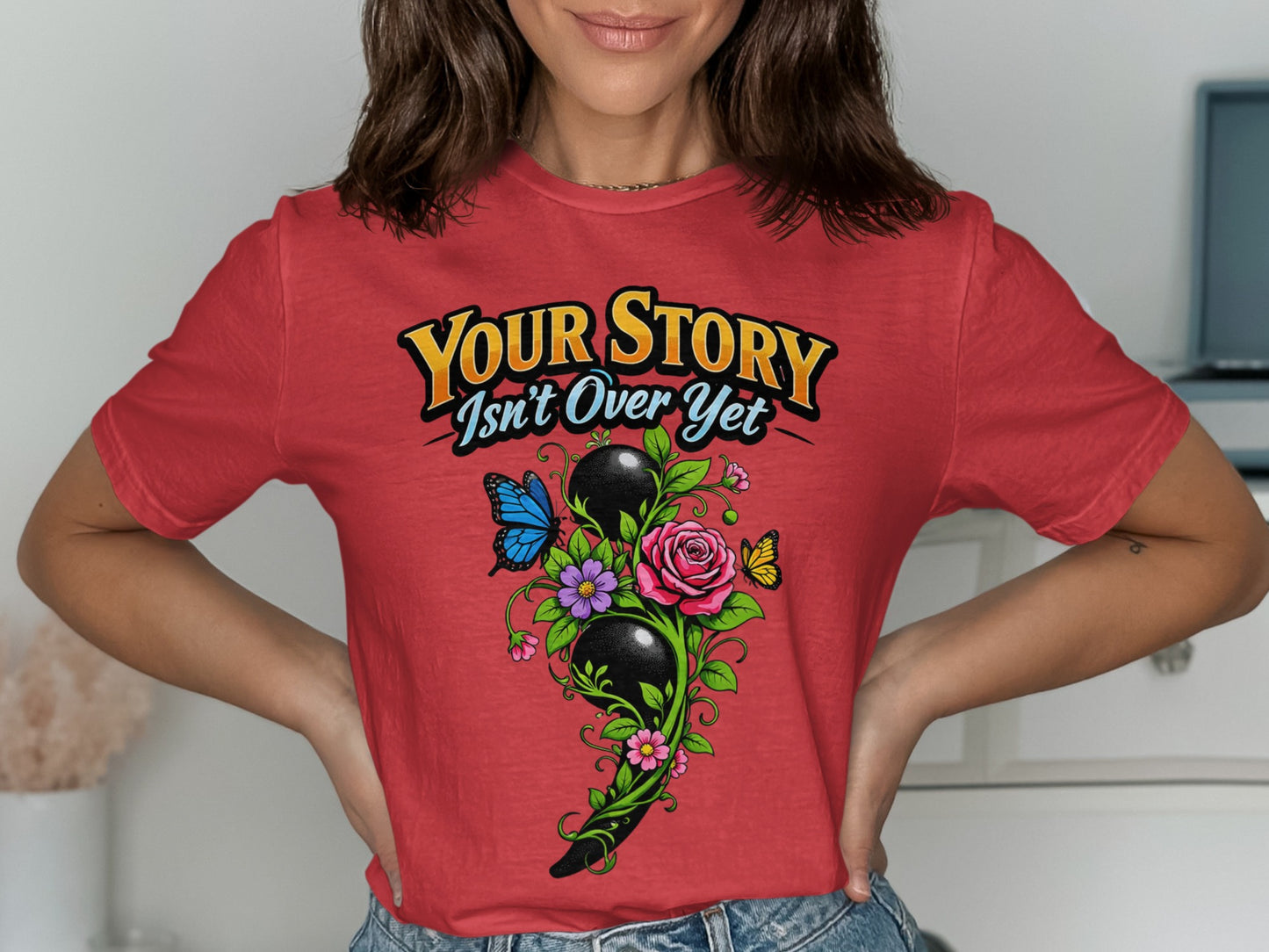 Red t-shirt with semicolon design, butterflies, flowers, and text "Your Story Isn't Over Yet".