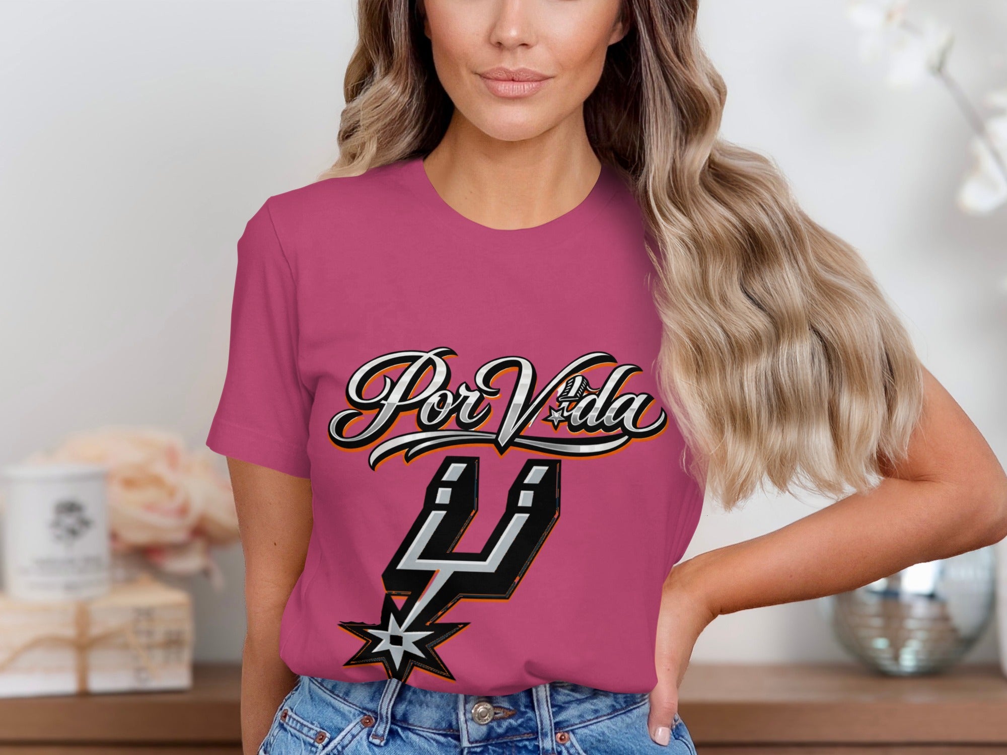 Pink t-shirt with "Por Vida" text and a sports team logo.