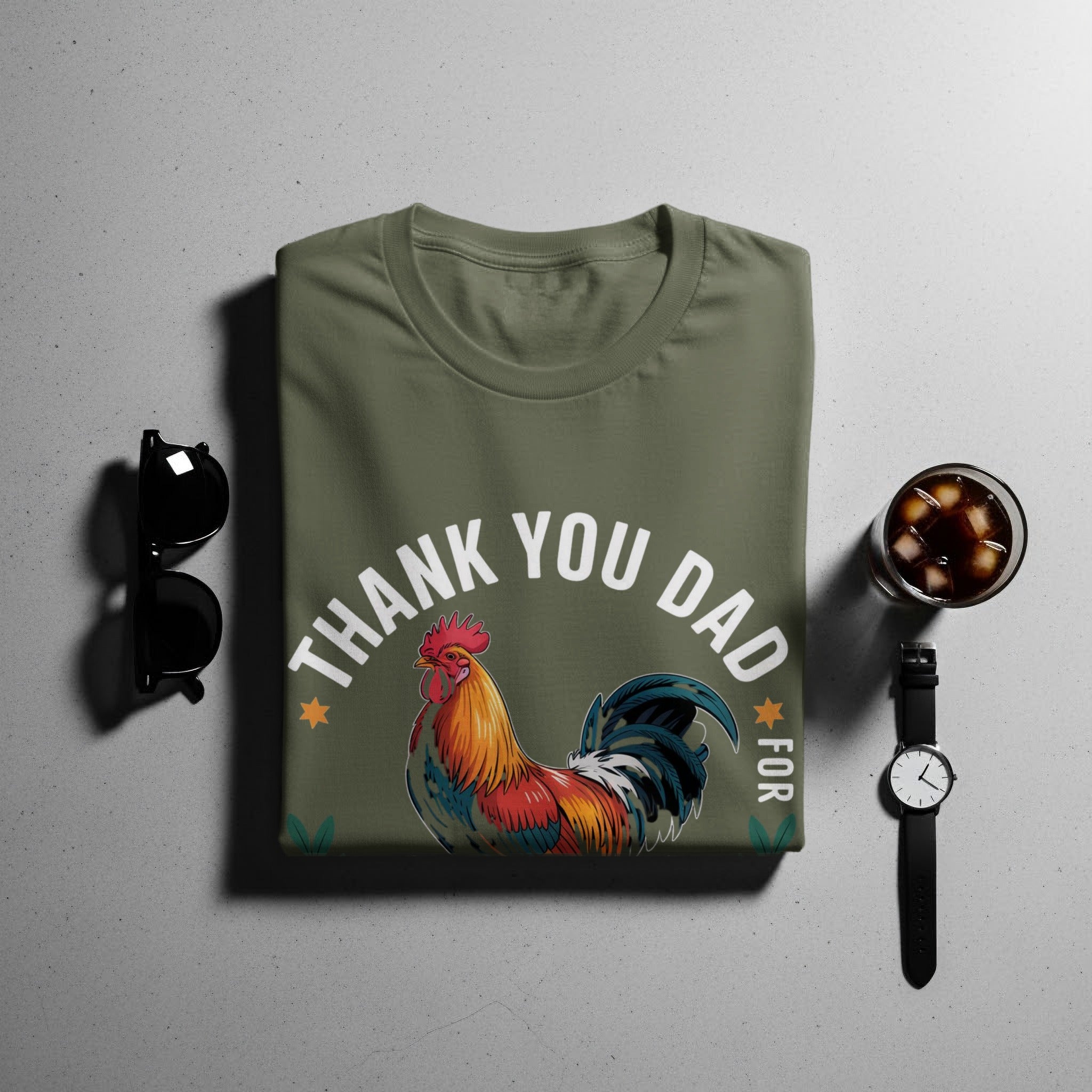 Green t-shirt with colorful rooster graphic and text "Thank You Dad For".