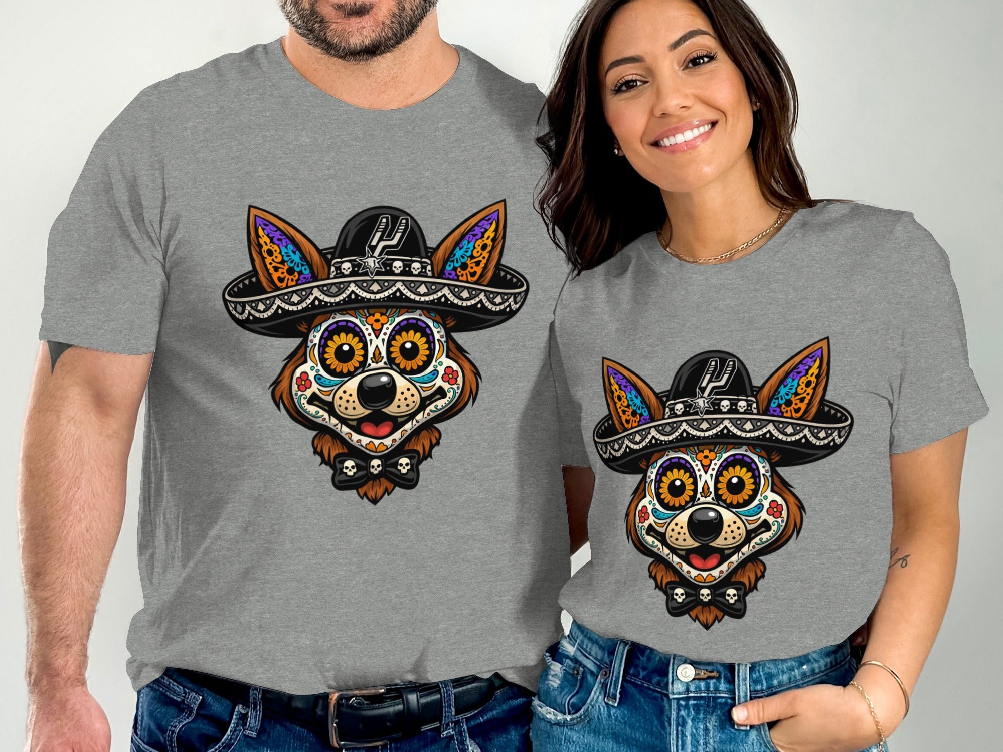 Couple wearing grey t-shirts with a colorful Dia de los Muertos dog graphic wearing a sombrero.