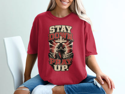 Red t-shirt with graphic "STAY DOWN PRAY UP" and praying figure in front of a cross.