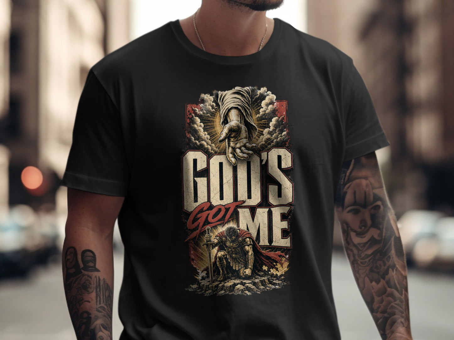 Black t-shirt with "God's Got Me" text and imagery of a hand and warrior.