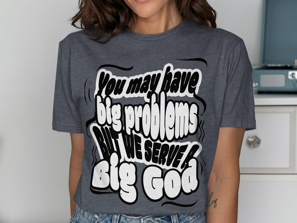 Dark gray t-shirt with white bubble text that reads "You may have big problems BUT WE SERVE Big God".