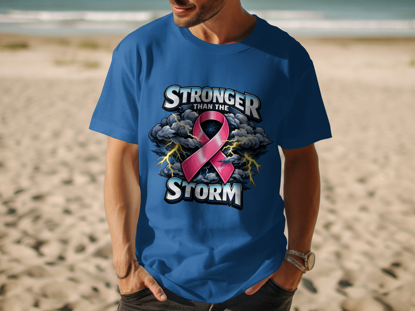 Blue t-shirt with "Stronger Than The Storm" text, pink ribbon, and stormy clouds.