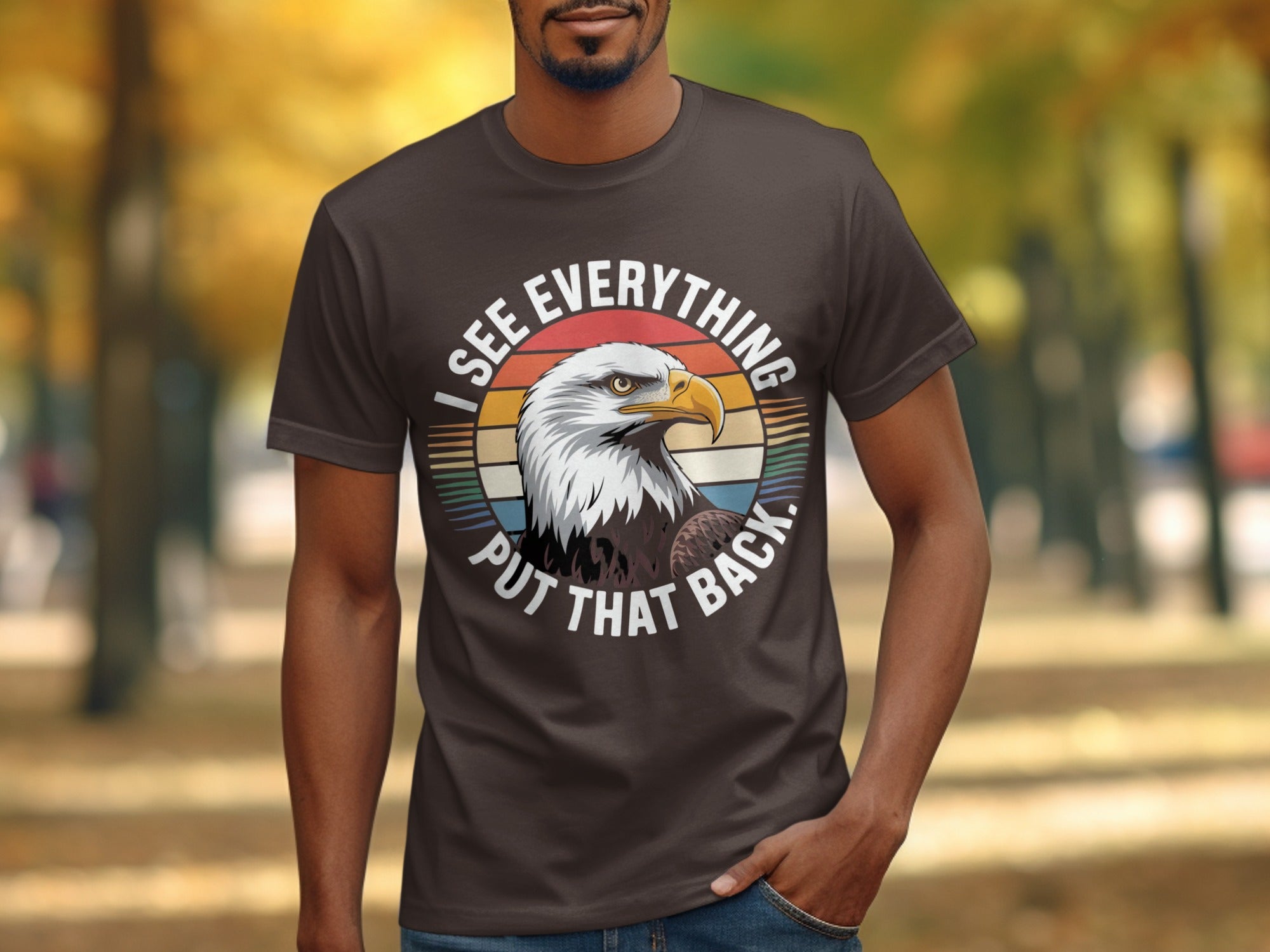 Brown t-shirt with an eagle and text "I see everything, put that back."