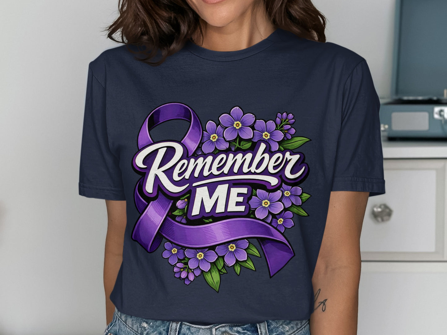 Dark blue t-shirt with purple ribbon and purple flowers, reads "Remember ME".