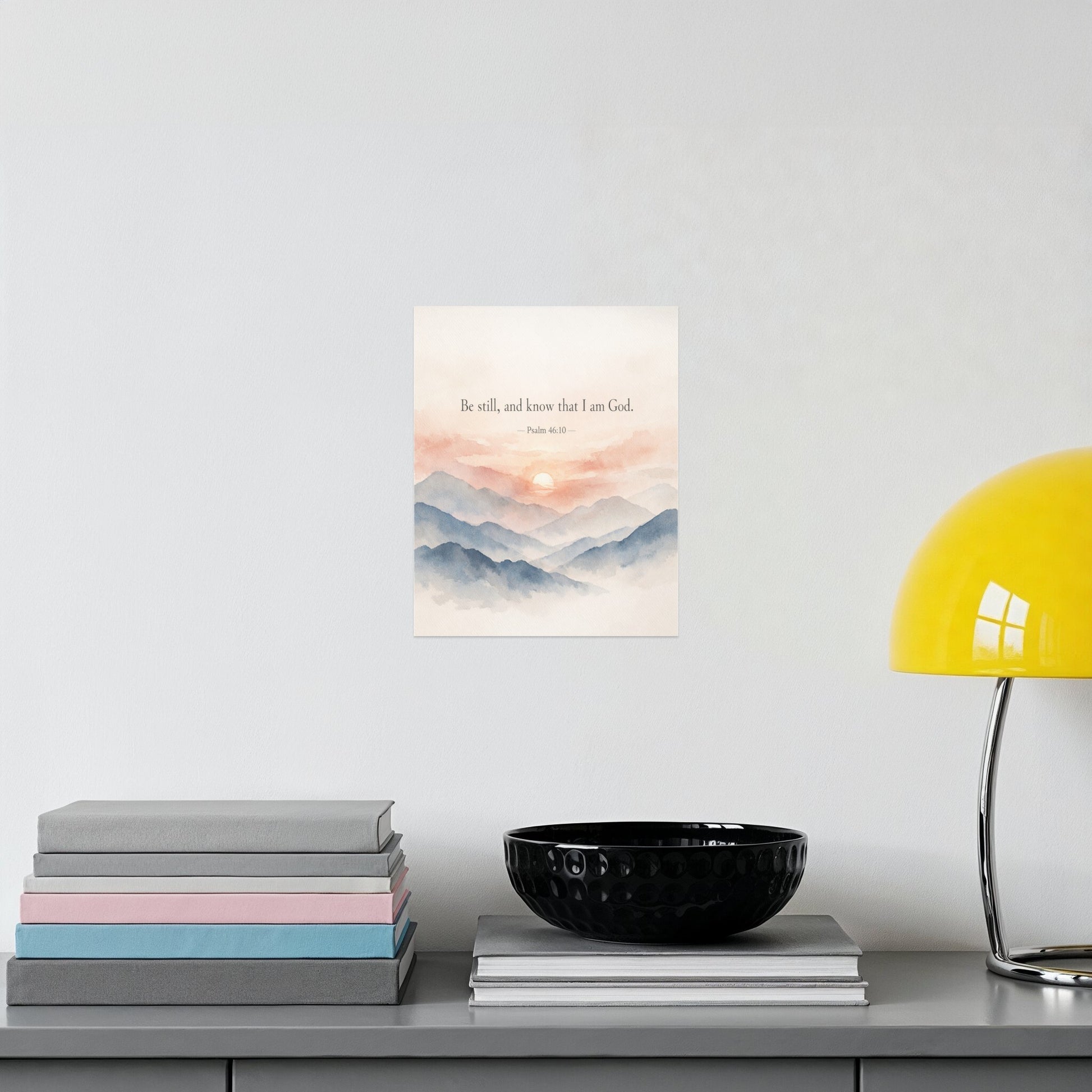 Watercolor art print with mountains, sunset, and text "Be still, and know that I am God."