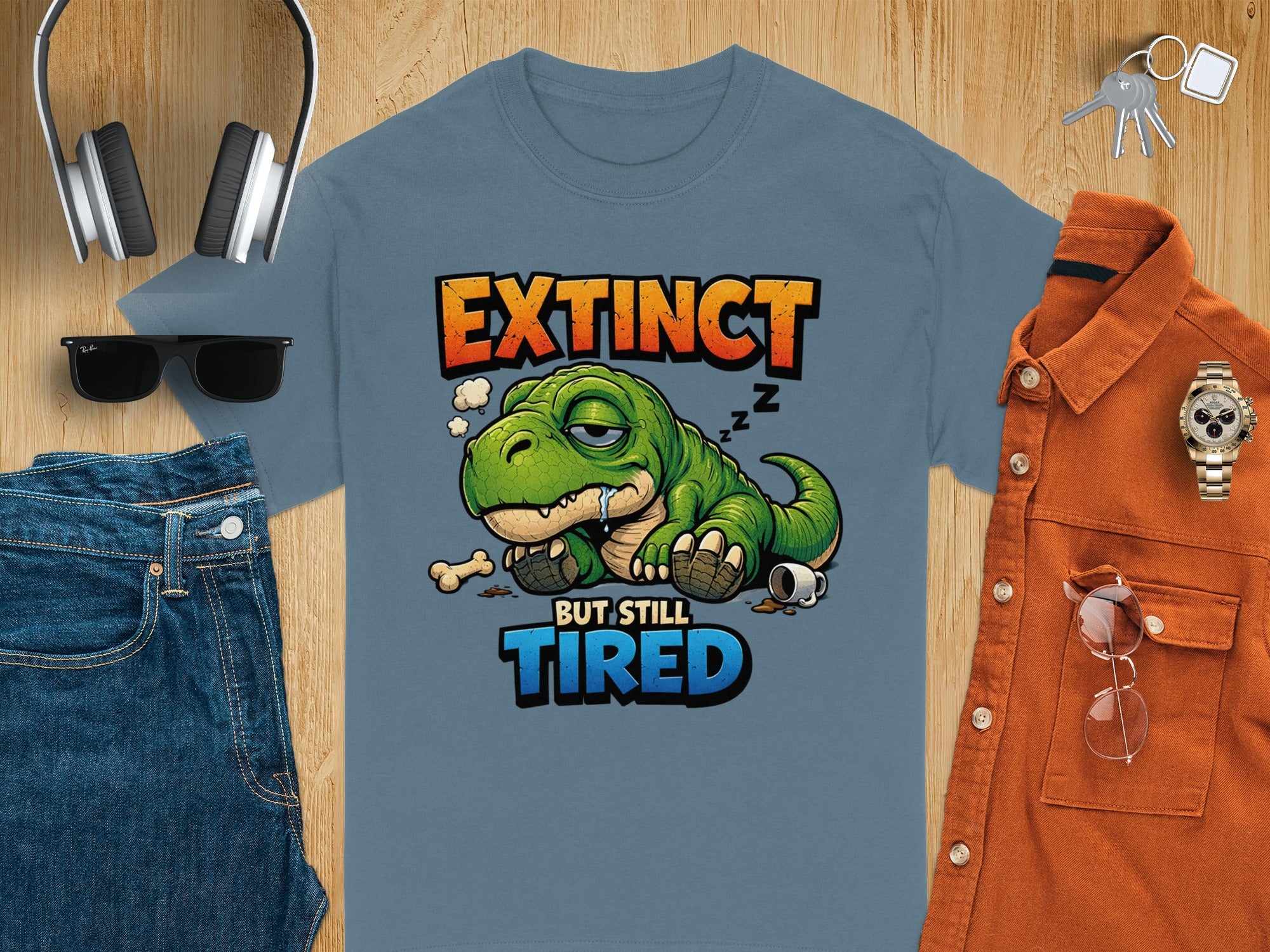 T-shirt with "Extinct But Still Tired" text and cartoon dinosaur graphic.