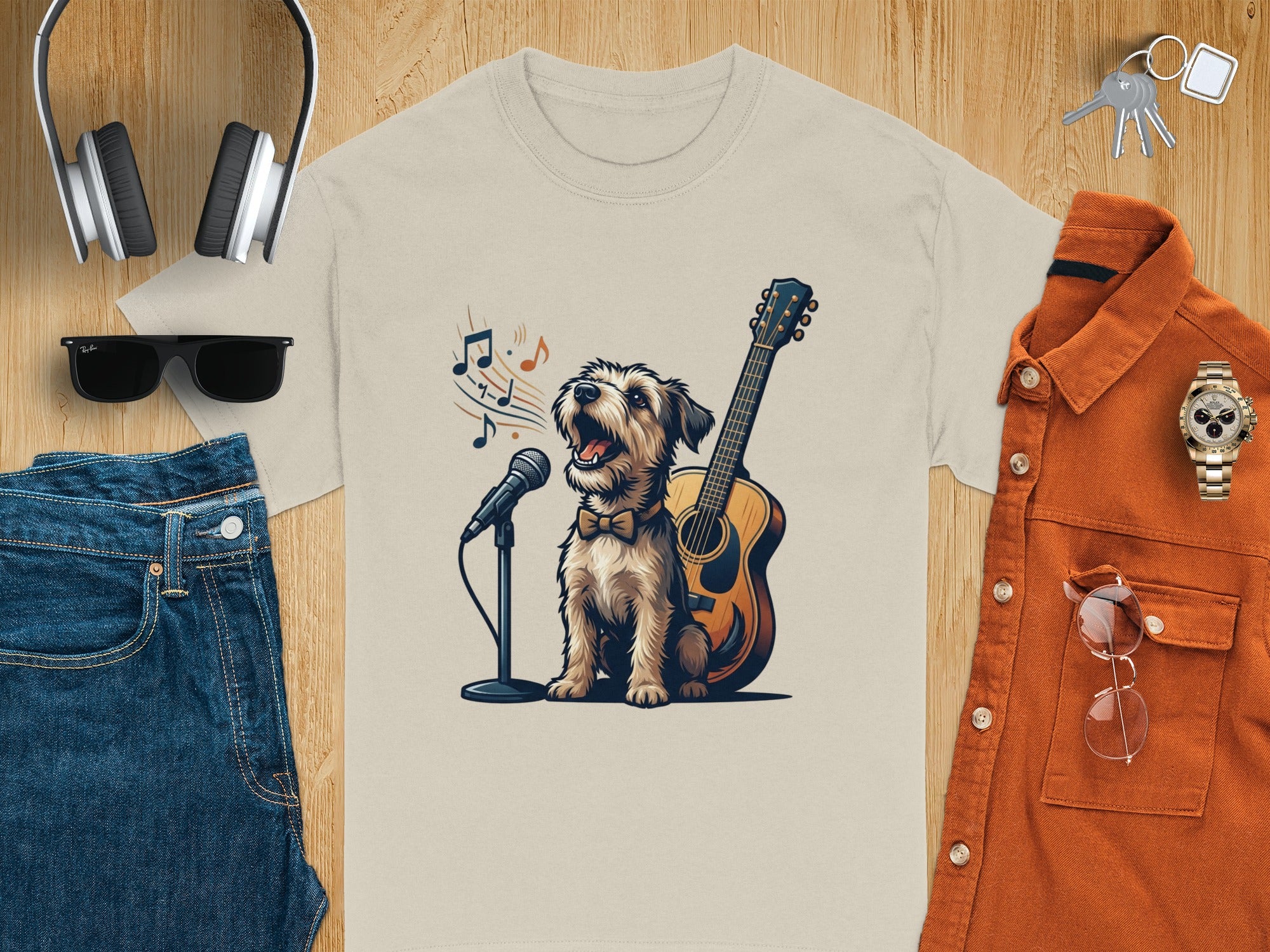 Dog singing with guitar and microphone graphic on a tan t-shirt.