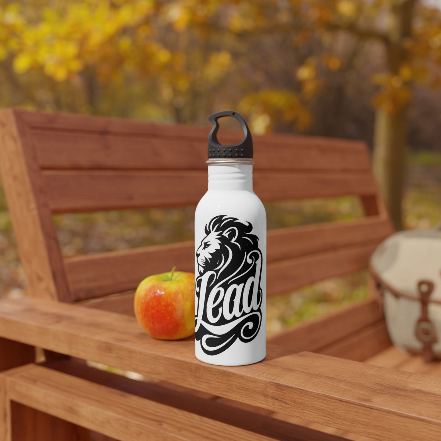 White water bottle with lion design and "Lead" text on a wooden bench.