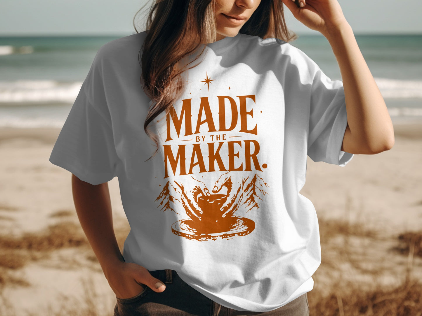 White t-shirt with "Made by the Maker" text and pottery hands graphic.