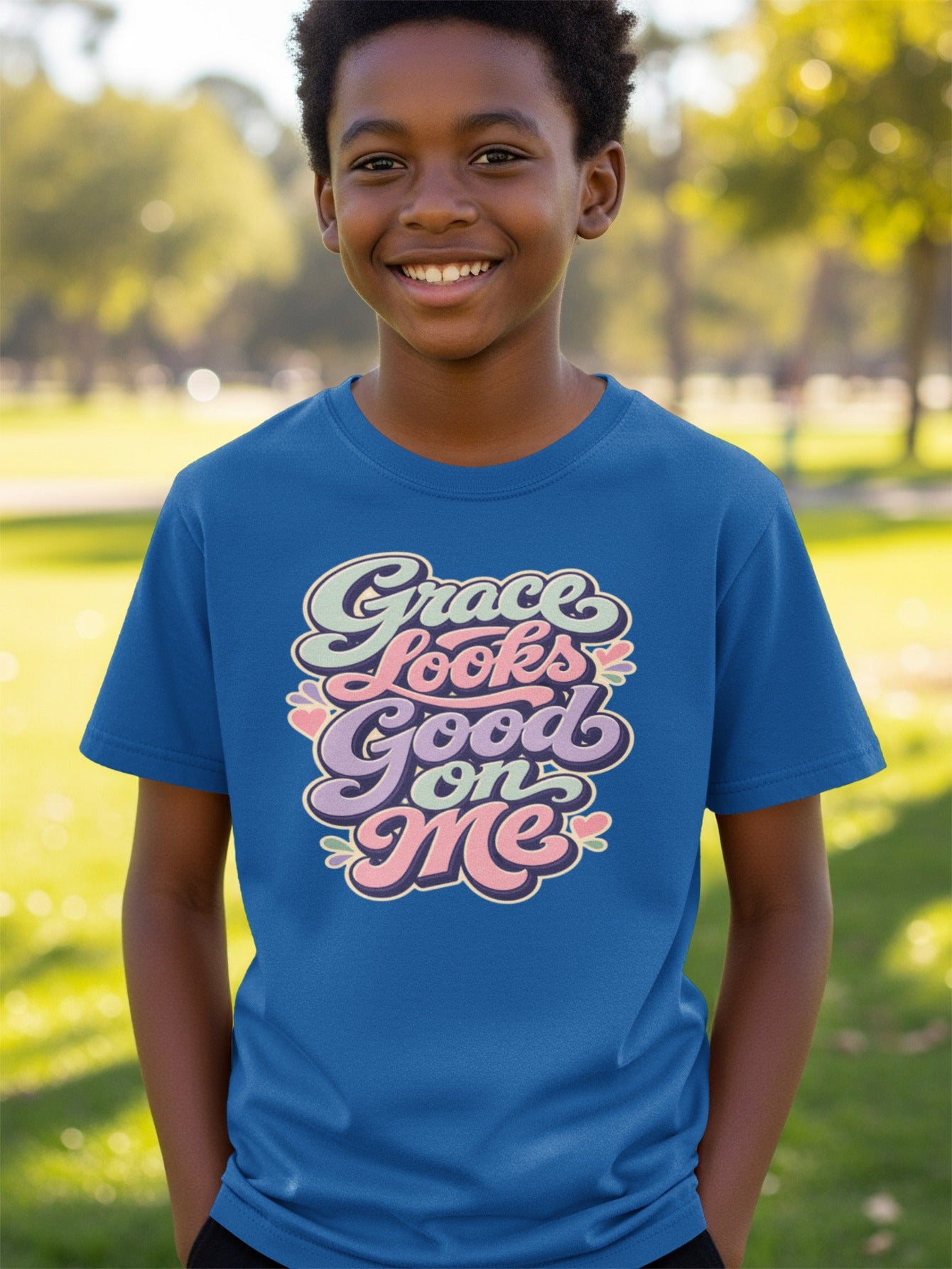 Boy wearing a blue t-shirt with "Grace Looks Good on Me" text design.