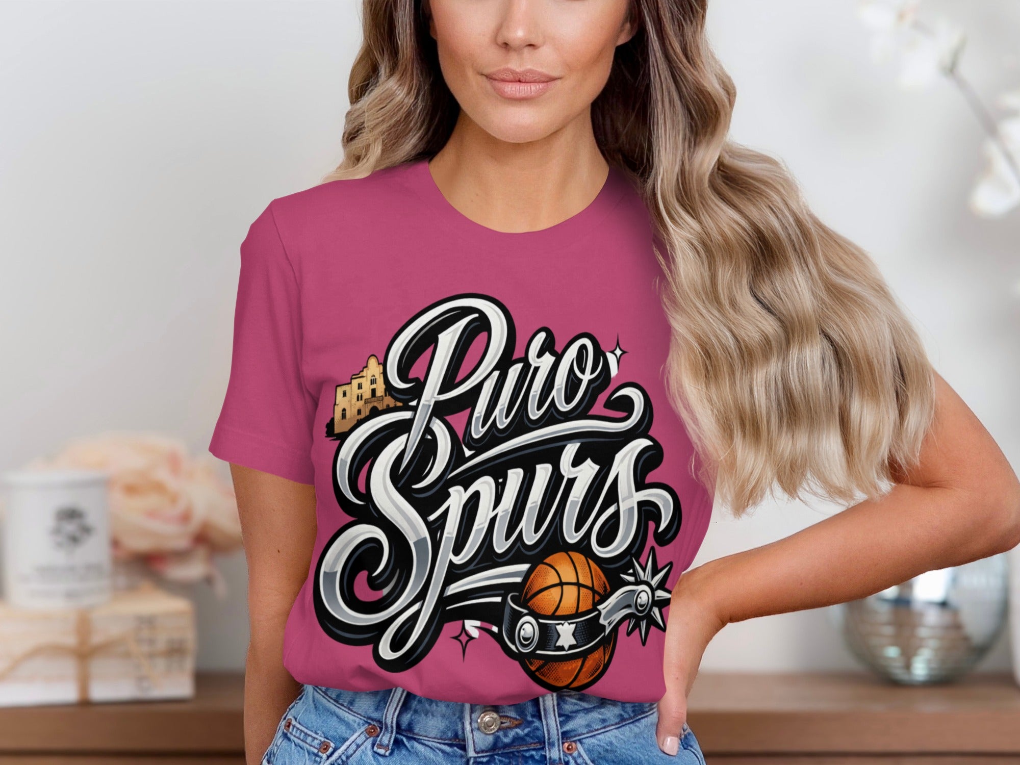 Puro Spurs text with basketball and spur graphic on pink shirt.