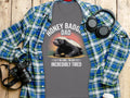 Grey t-shirt with honey badger wearing headphones and text: Honey Badger Dad, I Do Care, I'm Just Incredibly Tired.