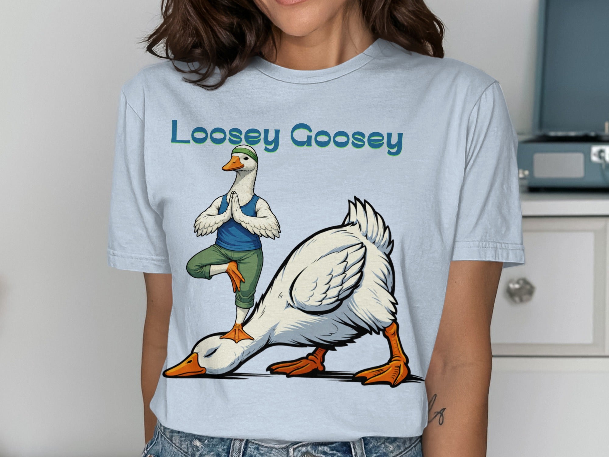 Loosey Goosey text with cartoon geese doing yoga poses on a t-shirt.