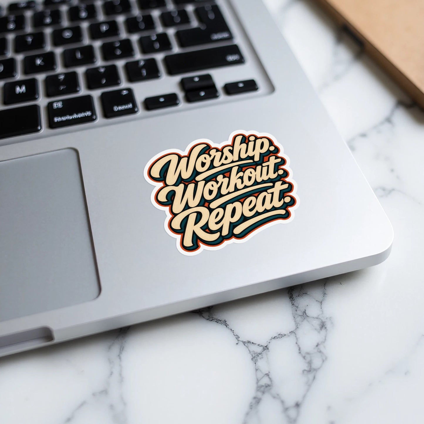 Sticker with text "Worship. Workout. Repeat." on a laptop.