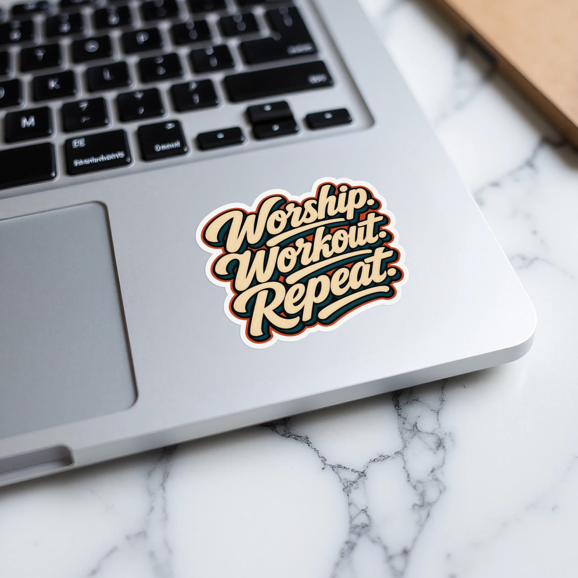 Sticker with text "Worship. Workout. Repeat." on a laptop.