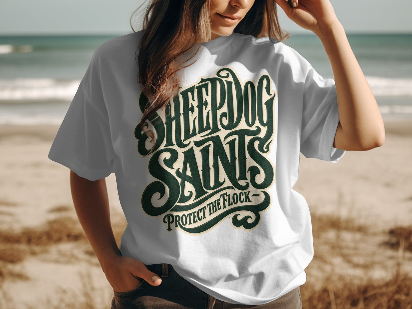 White t-shirt with dark green text reading "SHEEPDOG SAINTS PROTECT THE FLOCK".