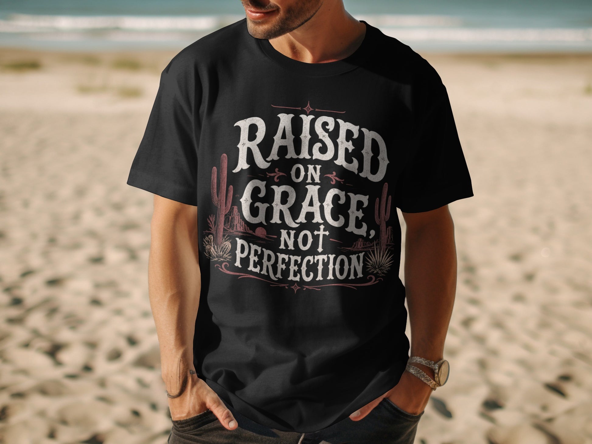 Black t-shirt with "Raised on Grace, Not Perfection" text and desert imagery.