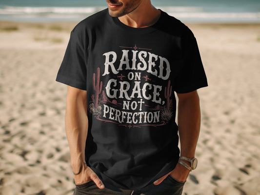 Black t-shirt with "Raised on Grace, Not Perfection" text and desert imagery.