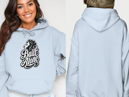 Light blue hoodie worn by a woman, featuring a "Built Alone" lion graphic on the front.