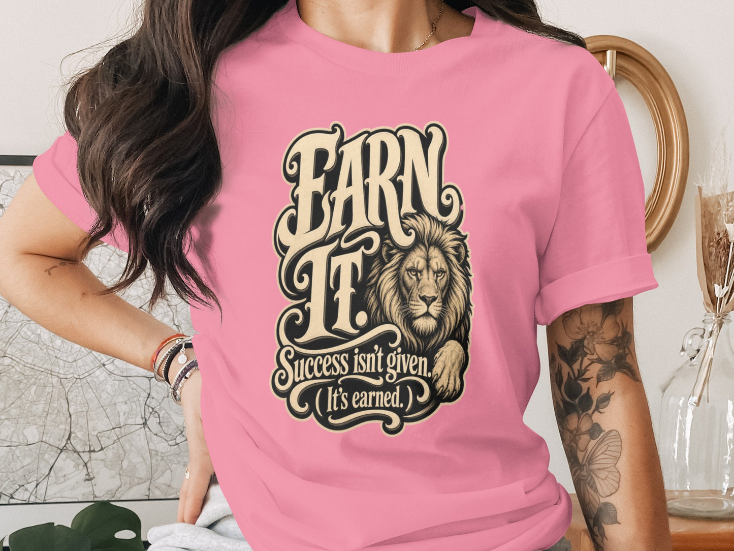 Pink t-shirt with "EARN IT. Success isn't given. (It's earned.)" and a lion.