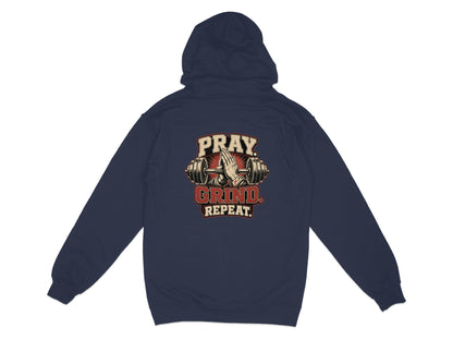 Navy hoodie with praying hands and barbell graphic, text reads "PRAY. GRIND. REPEAT."