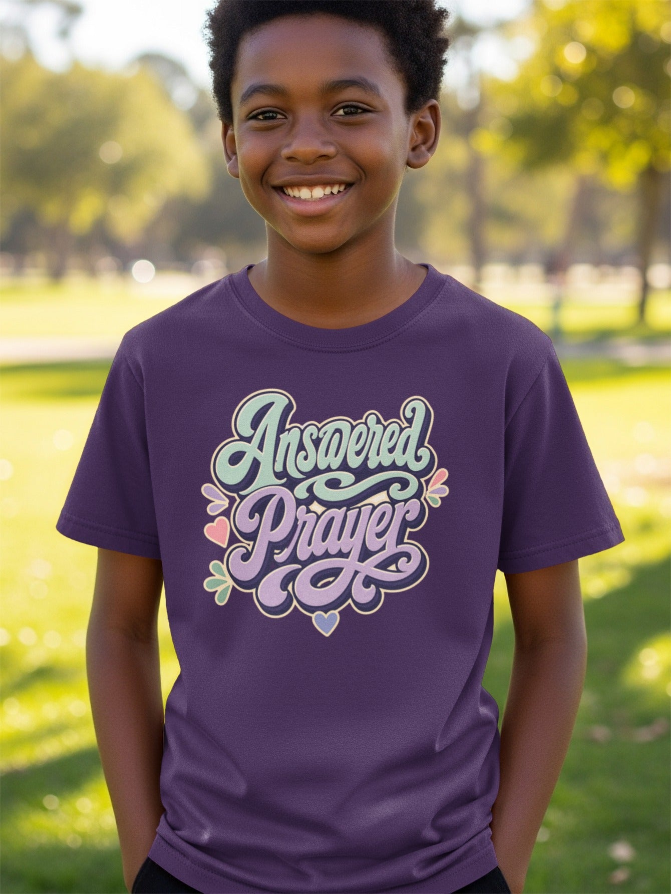 Boy wearing a purple t-shirt with "Answered Prayer" in stylized text.