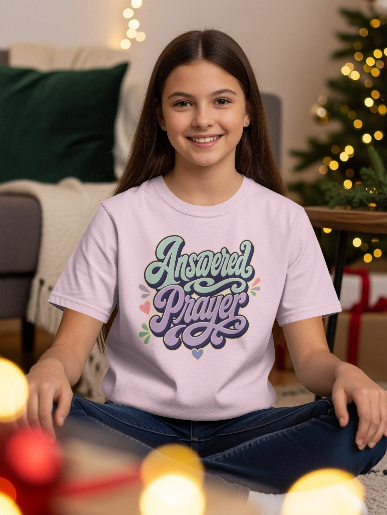 Girl wearing pink t-shirt with "Answered Prayer" text and colorful hearts.