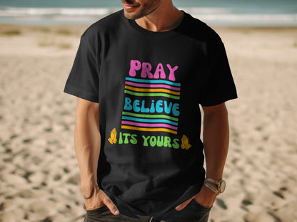 Black t-shirt with colorful "PRAY BELIEVE ITS YOURS" text and praying hands graphics.