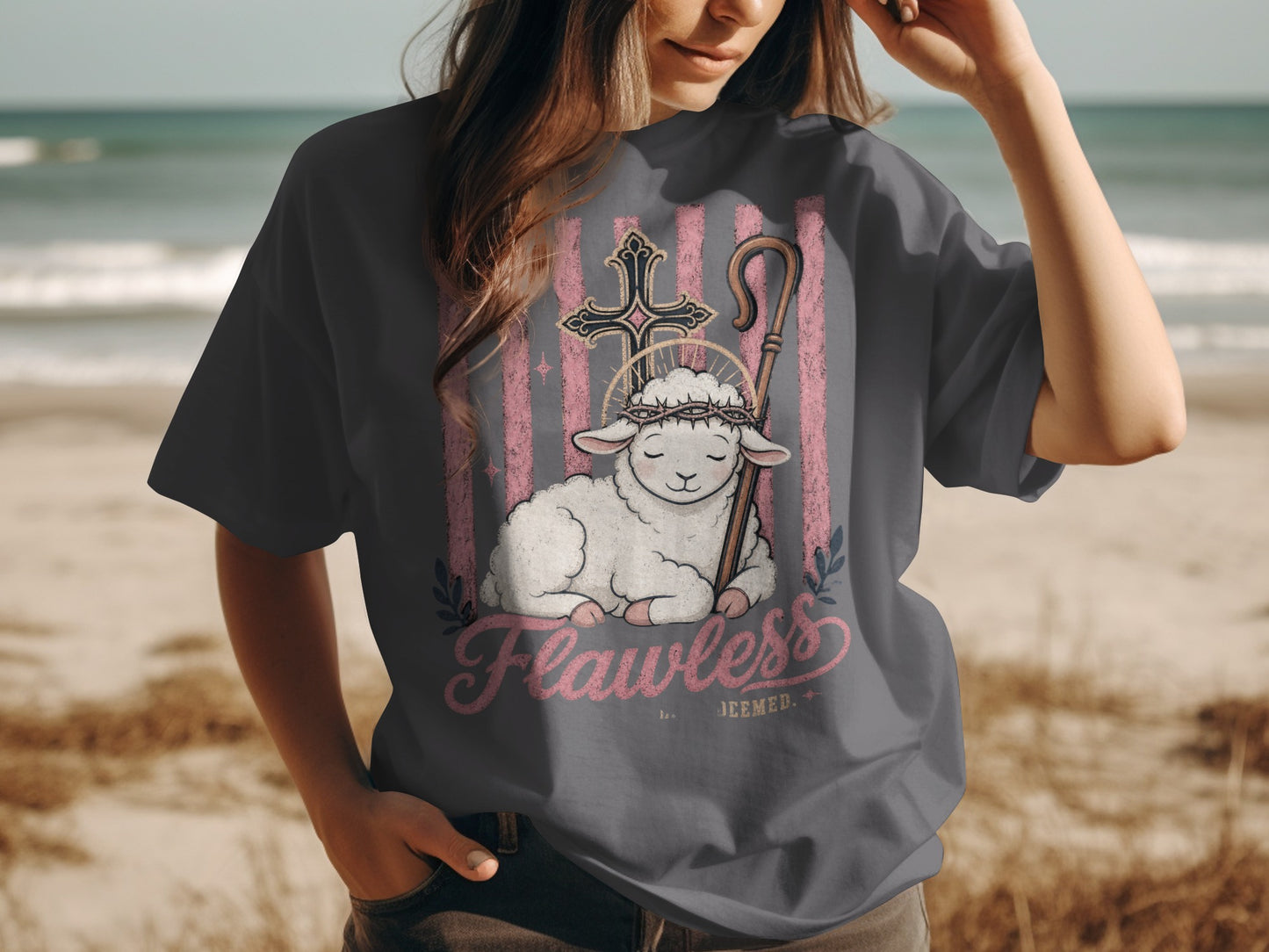 Graphic tee with a lamb, cross, shepherd's crook, halo, and "Flawless Deemed" text.