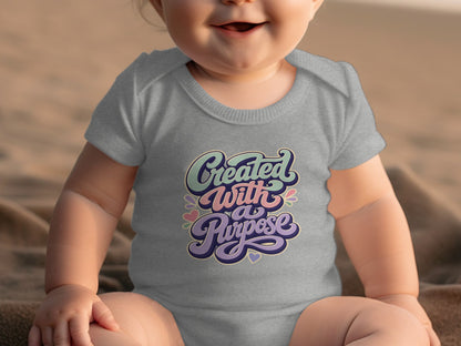 Grey baby onesie with "Created With a Purpose" text in retro lettering.